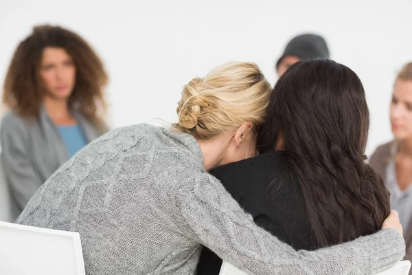 Mulheres abraçadas em grupo de reabilitação na terapia — Fotografia de Stock