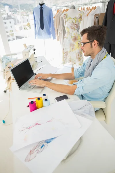 Koncentrált fiatal férfi divattervező használ laptop — Stock Fotó