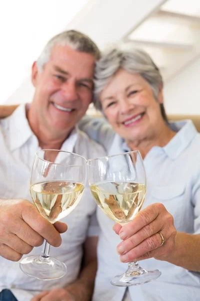 Seniorenpaar sitzt auf Couch und trinkt Weißwein — Stockfoto
