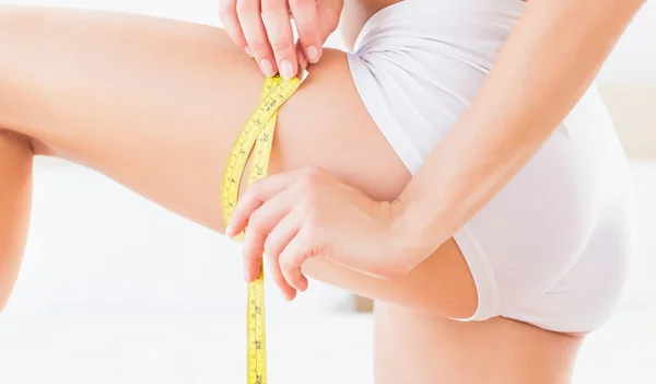 Toned woman measuring her thigh — Stock Photo, Image