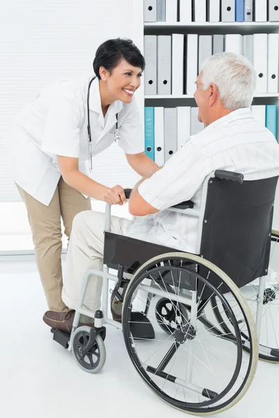 Female doctor talking to senior patient in wheelchair — Stock Photo, Image