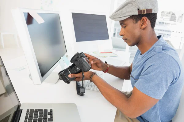 Fotoredacteur kijken naar digitale camera in office — Stockfoto