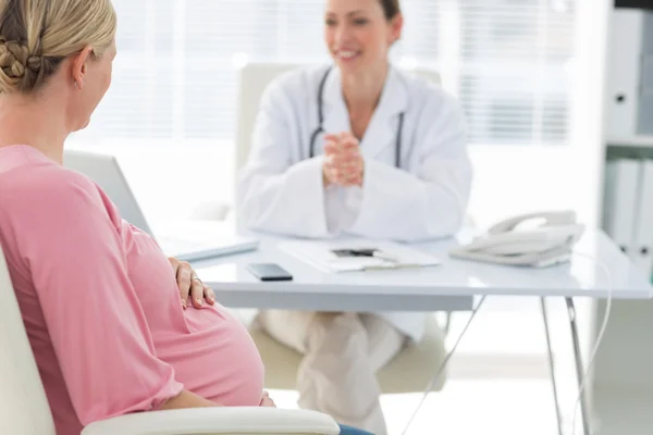 Expectant woman consulting doctor — Stock Photo, Image