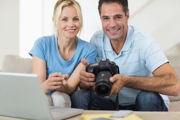 Coppia con fotocamera e laptop sul divano — Foto Stock