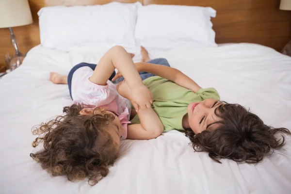 Rodzeństwo szczęśliwy grając w łóżku — Zdjęcie stockowe
