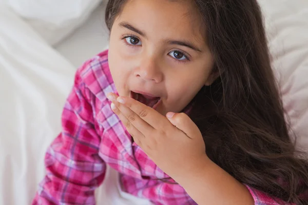 Young girl yawning in bed — Stock Photo, Image