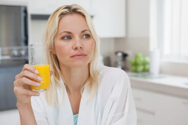 Mujer pensativa con jugo de naranja — Foto de Stock