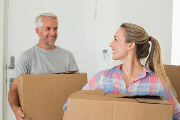 Happy couple carrying cardboard moving boxes — Stock Photo, Image