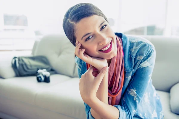 Brunette sitting on sofa — Stock Photo, Image