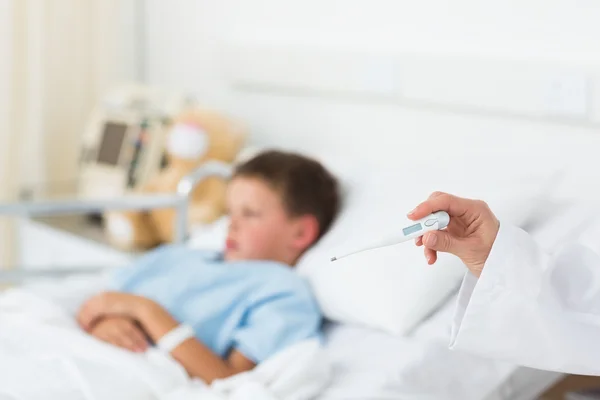 Médico segurando termômetro com menino no hospital — Fotografia de Stock