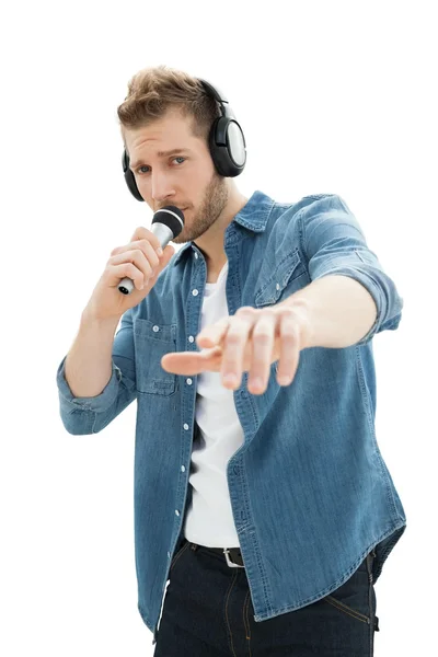 Portrait of a young man singing into microphone — Stock Photo, Image