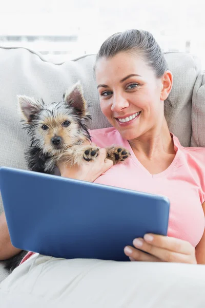 Donna attraente utilizzando tablet pc con il suo terrier yorkshire — Foto Stock