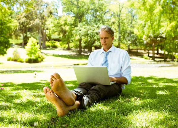 Homme d'affaires utilisant un ordinateur portable dans le parc — Photo