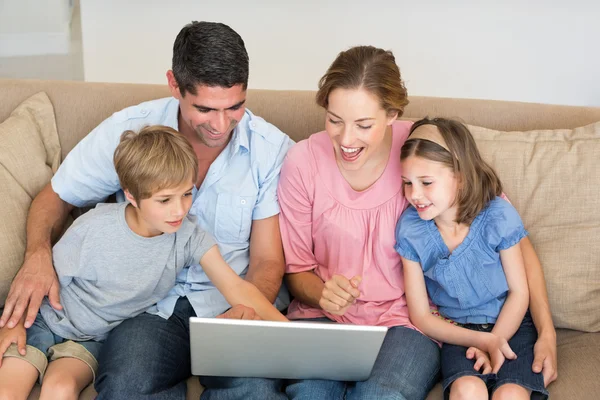 Familj med laptop ihop soffan — Stockfoto