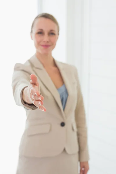 Sorridente agente immobiliare tenendo la mano fuori per la fotocamera — Foto Stock