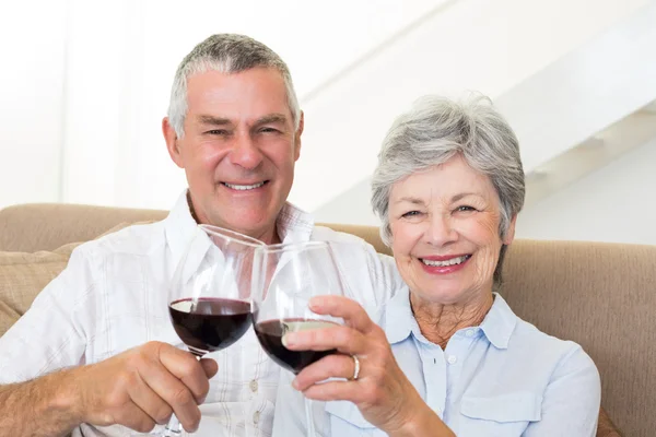 Senior koppel zittend op de Bank met rode wijn — Stockfoto