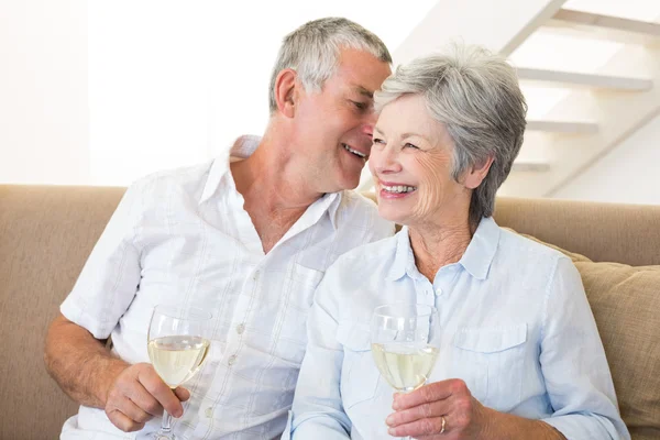 Coppia anziana seduta sul divano a bere vino bianco — Foto Stock