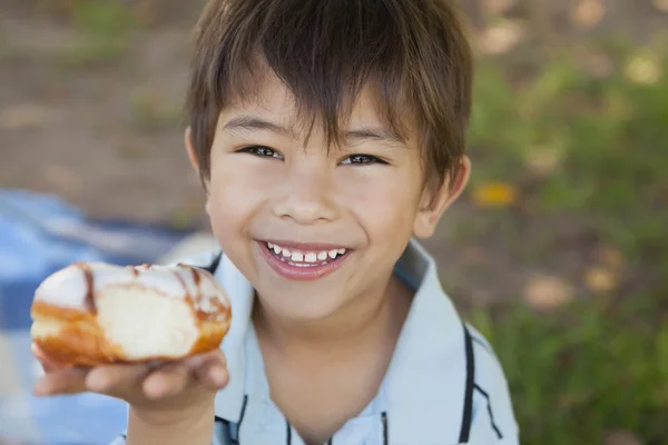 Gelukkige jongen hyolding hamburger in park — Stockfoto