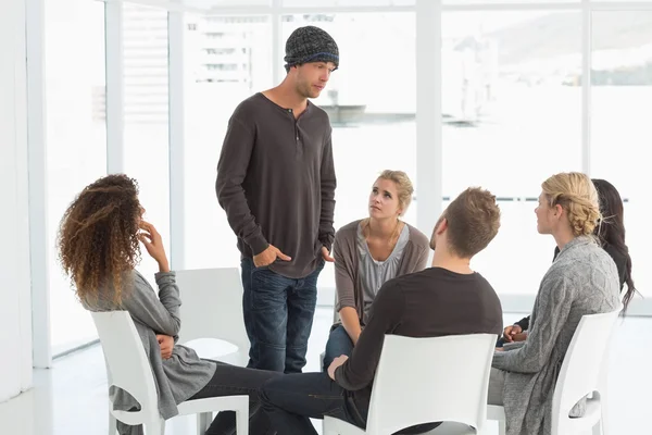 Rehab group listening to man standing up introducing himself — Stock Photo, Image