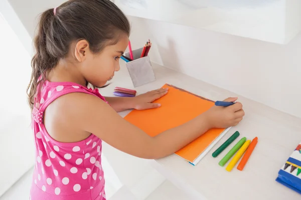 Girl drawing on orange paper — Stock Photo, Image