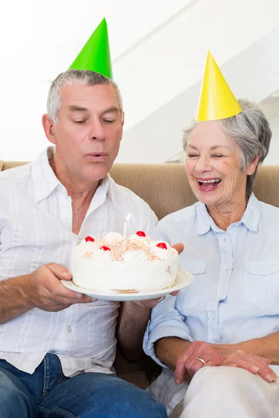 Senior couple sitting on couch celebrating a birthday — Stock Photo, Image