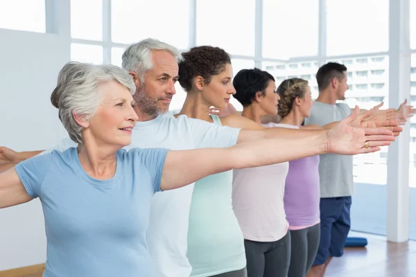 Klass stretching händer i rad på yogaklass — Stockfoto