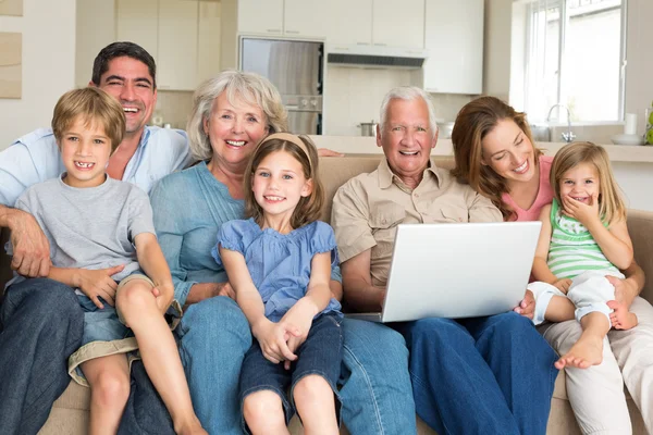 Glad familj med laptop — Stockfoto