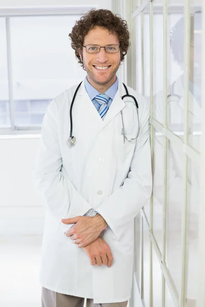 Happy handsome male doctor standing in hospital — Stock Photo, Image