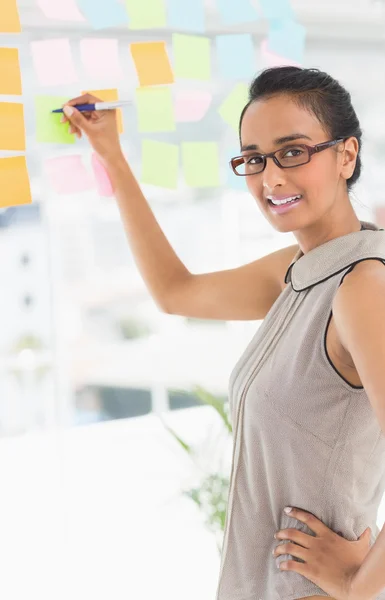 Diseñador escribiendo en notas adhesivas en la ventana — Foto de Stock