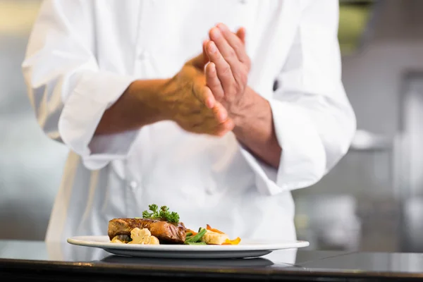 Mid section of a chef putting salt in kitchen — Stock Photo, Image
