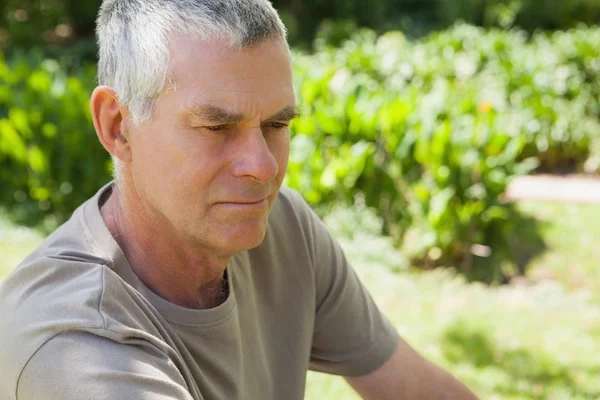 Thoughtful mature man at the park — Stock Photo, Image