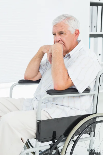 Vista lateral de um homem idoso triste sentado em cadeira de rodas — Fotografia de Stock