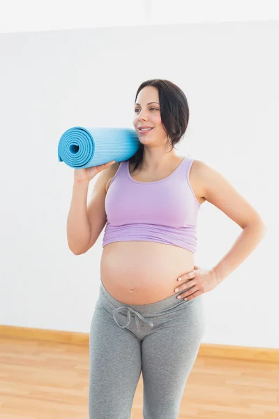 Feliz mulher grávida segurando tapete de exercício — Fotografia de Stock