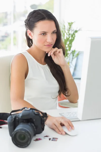 Fotograaf zit op haar bureau gericht — Stockfoto