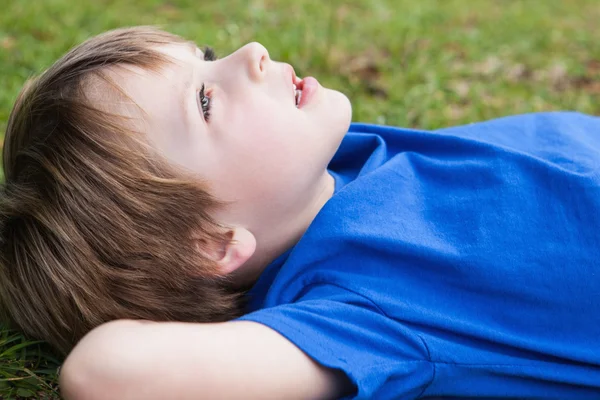 Avslappnad pojken ligga på park — Stockfoto