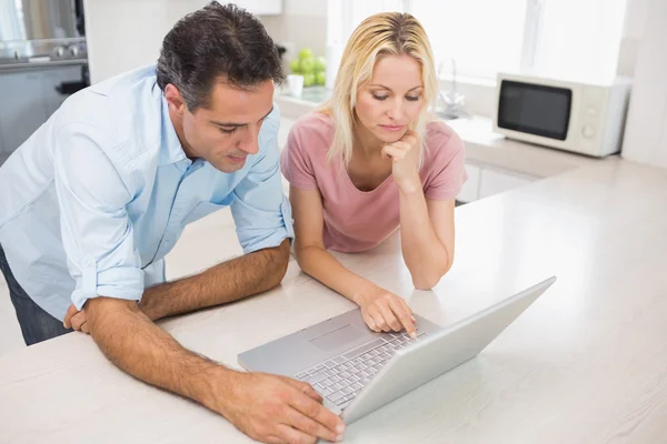 Concentrated couple using laptop — Stock Photo, Image