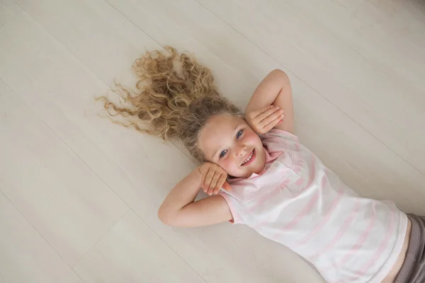 Sorrindo menina deitada no chão — Fotografia de Stock