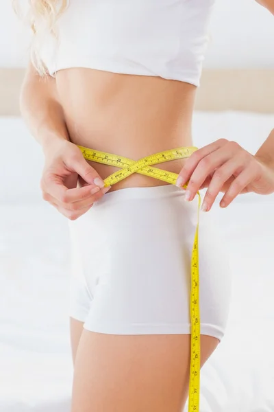 Toned woman measuring her waist — Stock Photo, Image