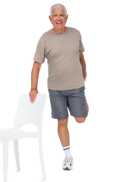 Happy senior man stretching leg — Stock Photo, Image