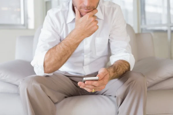 Mid section of man text messaging at home — Stock Photo, Image