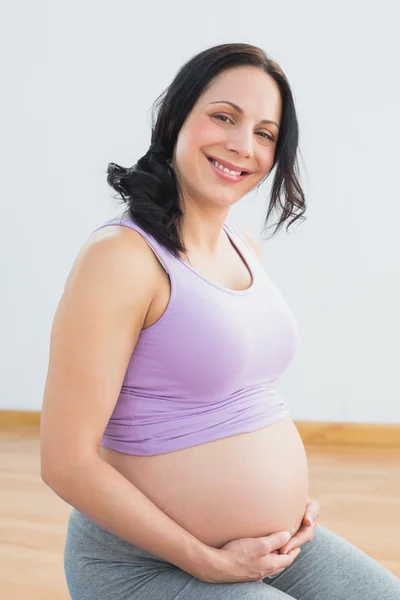 Felice bruna incinta sorridente alla macchina fotografica — Foto Stock