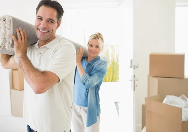 Casal transportando tapete laminado — Fotografia de Stock