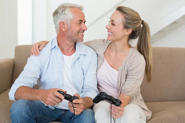 Pareja feliz divirtiéndose en el sofá jugando videojuegos —  Fotos de Stock