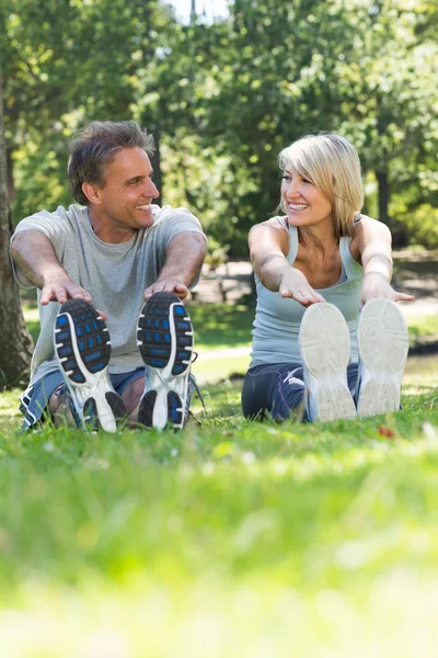 Couple stretching in the park — Stock Photo, Image