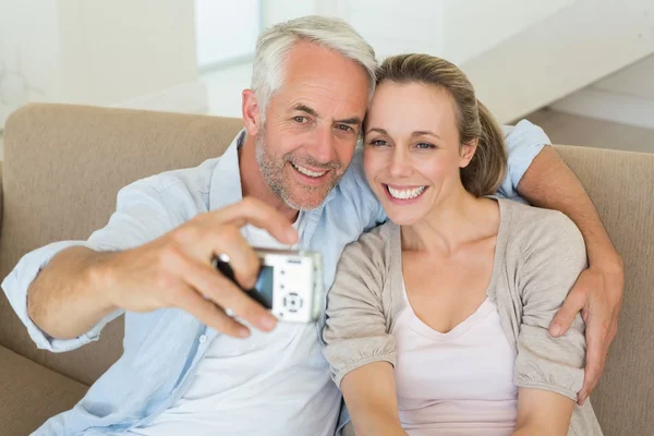 Šťastný pár, společně s selfie na gauči — Stock fotografie