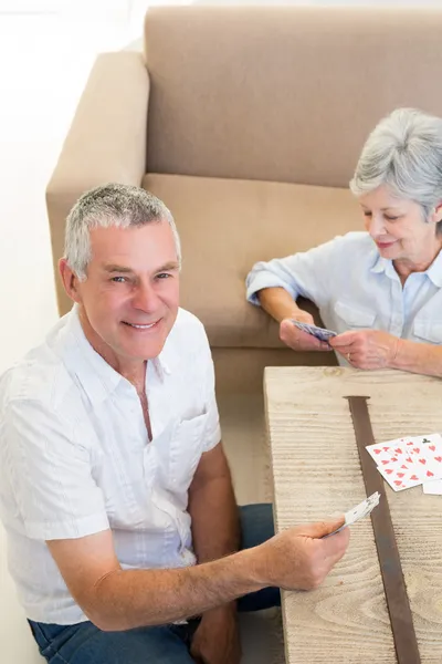 Pareja mayor sentada en el piso jugando a las cartas —  Fotos de Stock