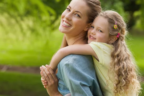 Woman carrying girl at park — Stock Photo, Image