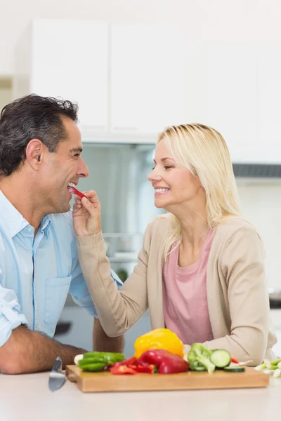 Woman feeding man vegetable — Stock Photo, Image