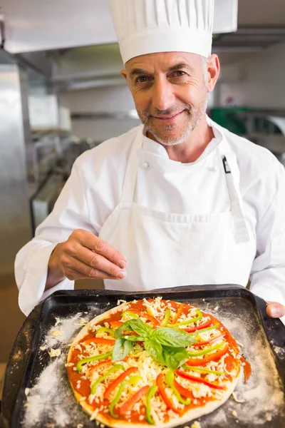 Уверенный мужчина шеф-повар держит приготовленную еду на кухне — стоковое фото