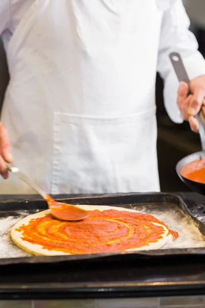 Mitten in der Küche bereitet ein Koch Pizza zu — Stockfoto